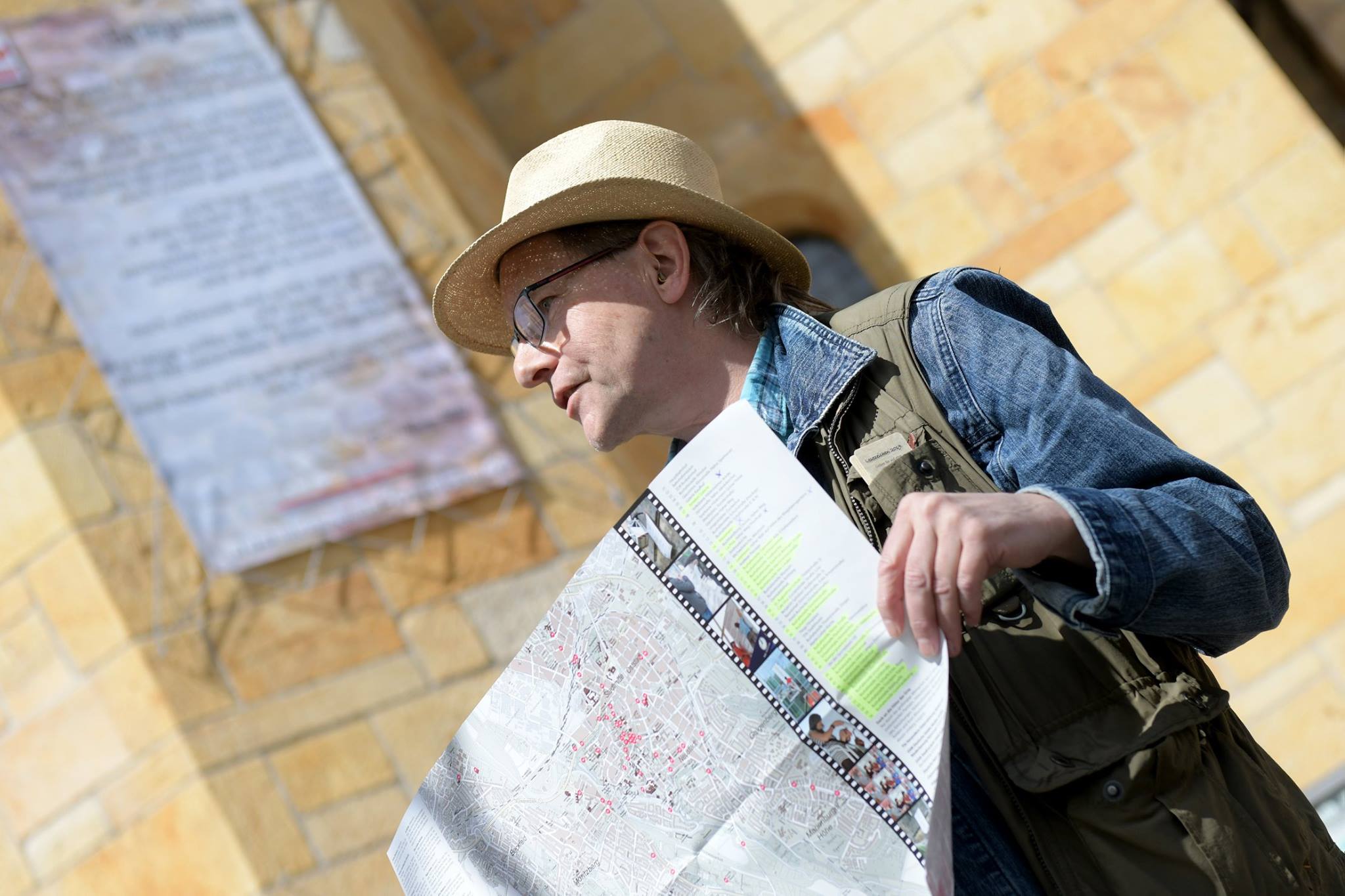 Jo Köhler steht vor der Michaeliskirche und hält einen Stadtplan in der Hand