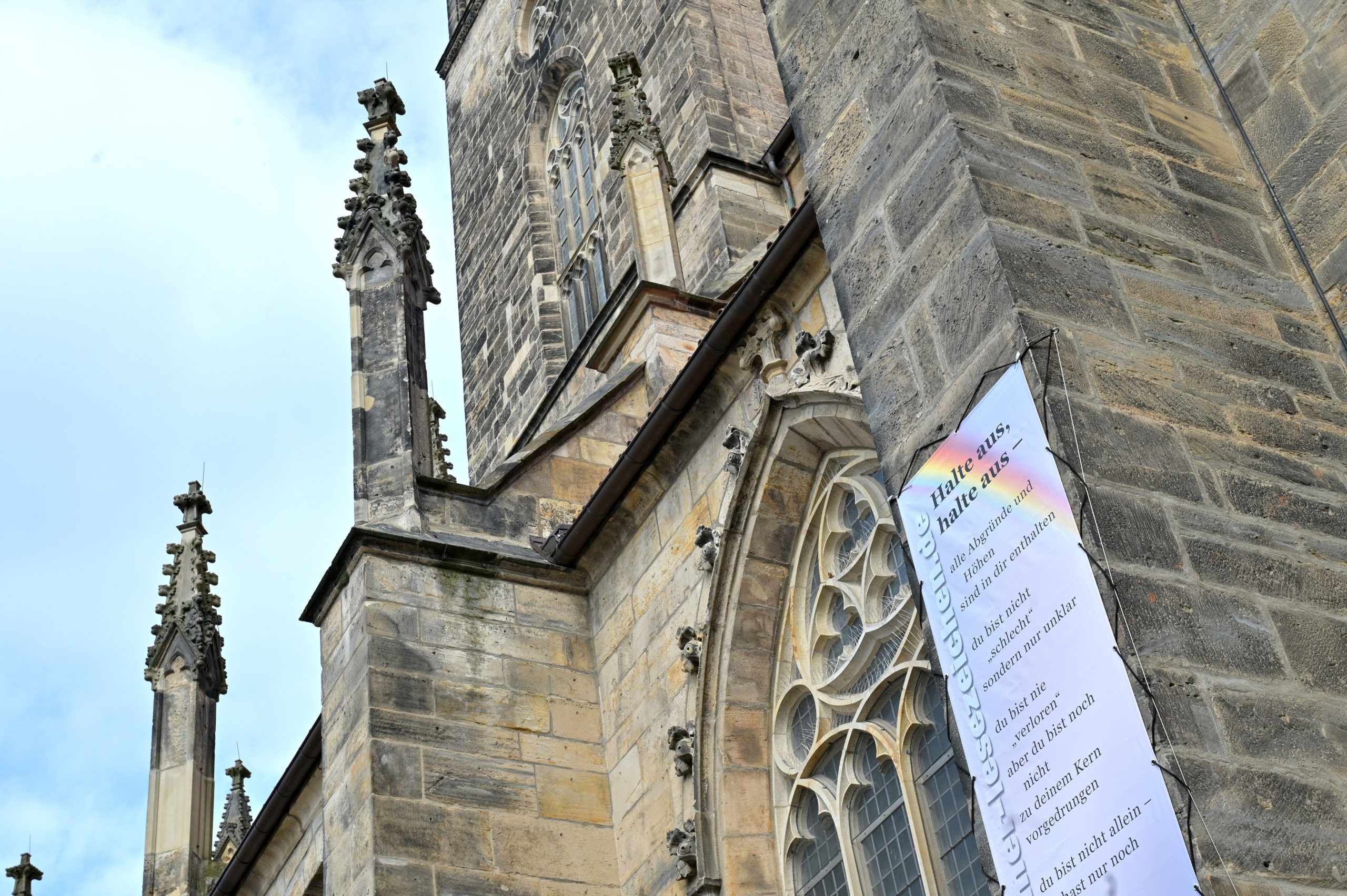 Das Gedichtbanner mit dem Text "Halte aus, Halte aus" hängt an der Andreaskirche.