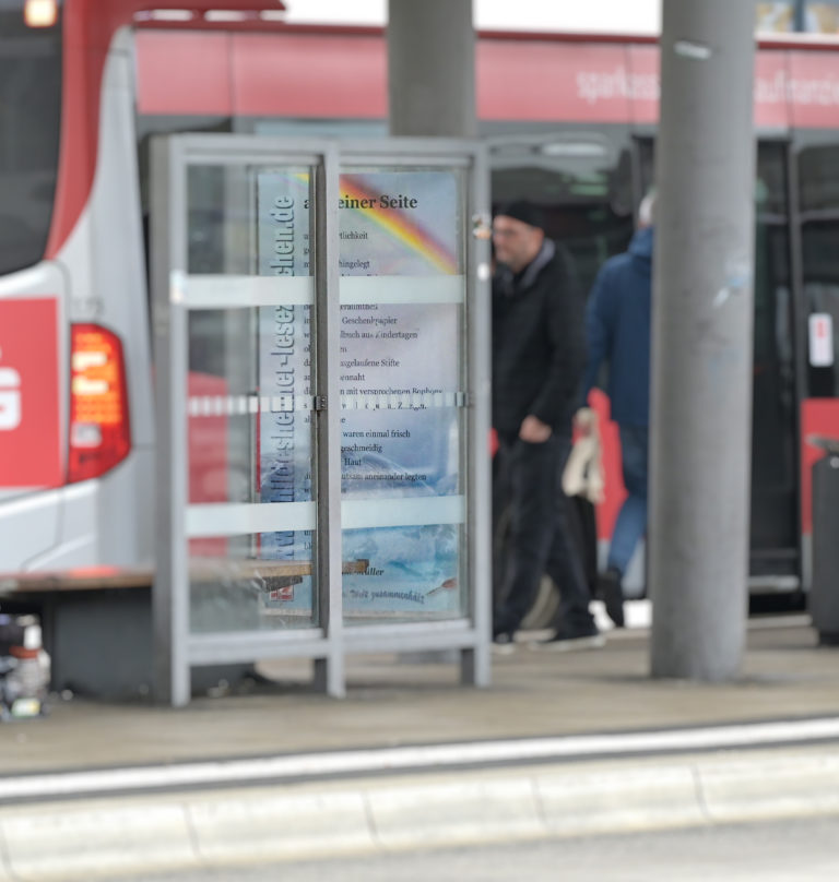 Ein Gedichtbanner hängt am Busbahnhof an der Haltestelle.